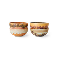 Set of four ceramic bowls with earthy tones on a white background