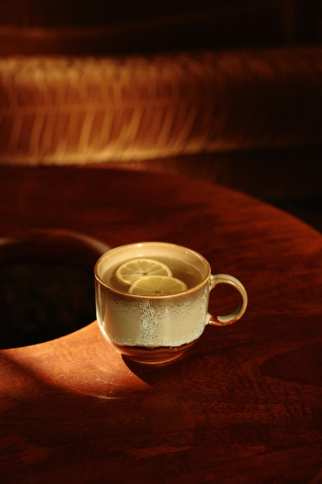 Tea cup with lemon slices on a textured surface