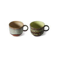 Two ceramic mugs with rustic finishes on a white background