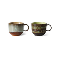 Two ceramic mugs with rustic glaze on a white background
