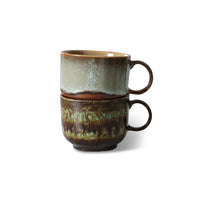 Two stacked ceramic mugs with a textured finish on a white background