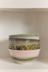 Stack of ceramic bowls with different patterns on a neutral background