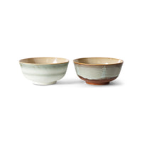 Two ceramic bowls with a speckled glaze on a white background