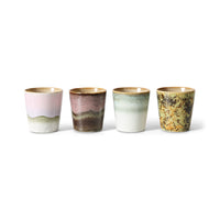 Four ceramic cups with gradient glaze colors on a white background