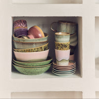 Set of ceramic bowls and cups in a white cabinet