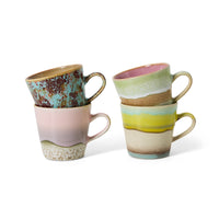 Two ceramic mugs with multicolored glaze patterns on a white background
