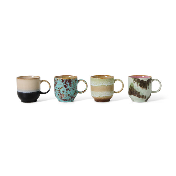 Set of four ceramic mugs with different earthy color palettes on a white background