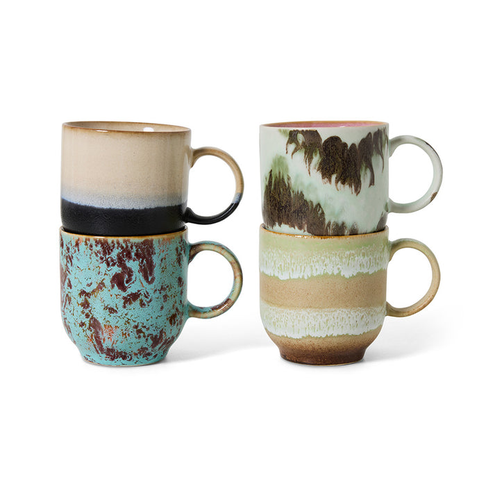 Set of four ceramic mugs with unique designs on a white background