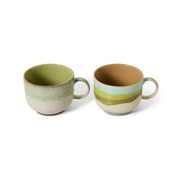 Two ceramic mugs with green and brown glaze on a white background