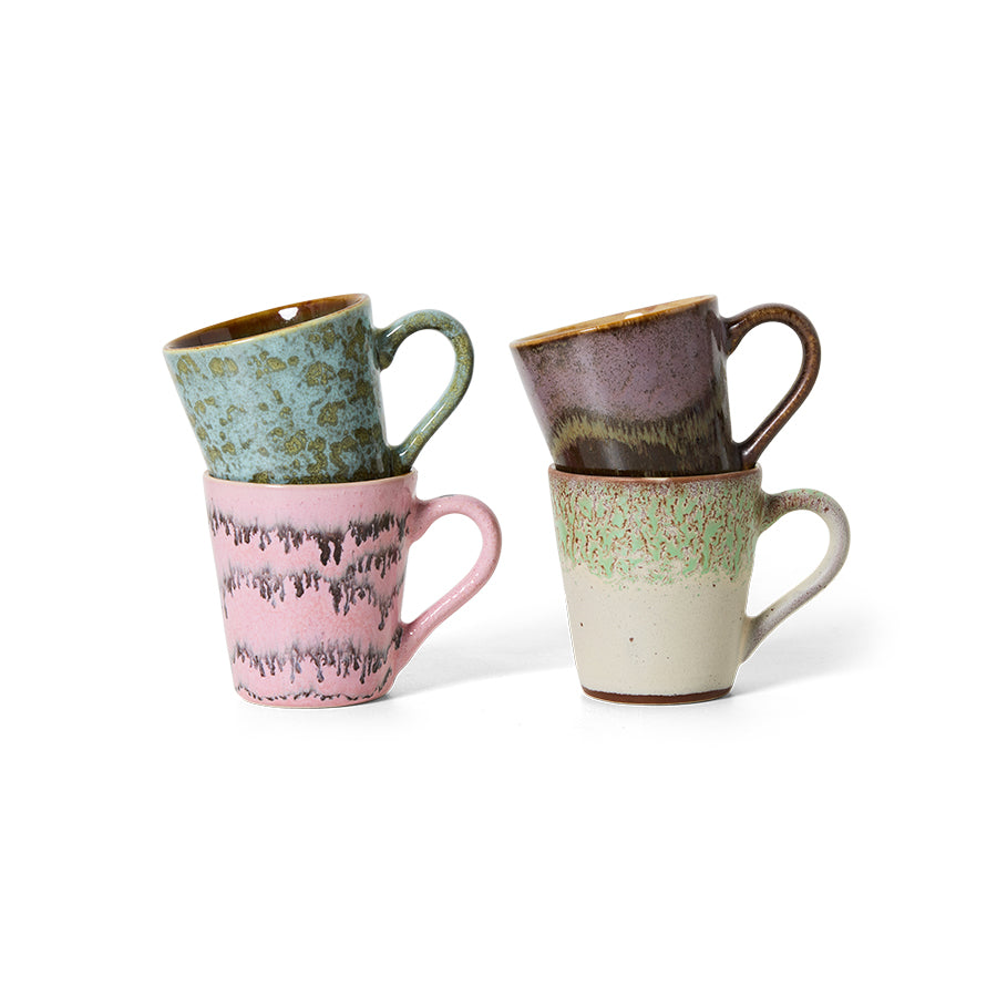 Set of four ceramic mugs with different patterns and colors on a white background