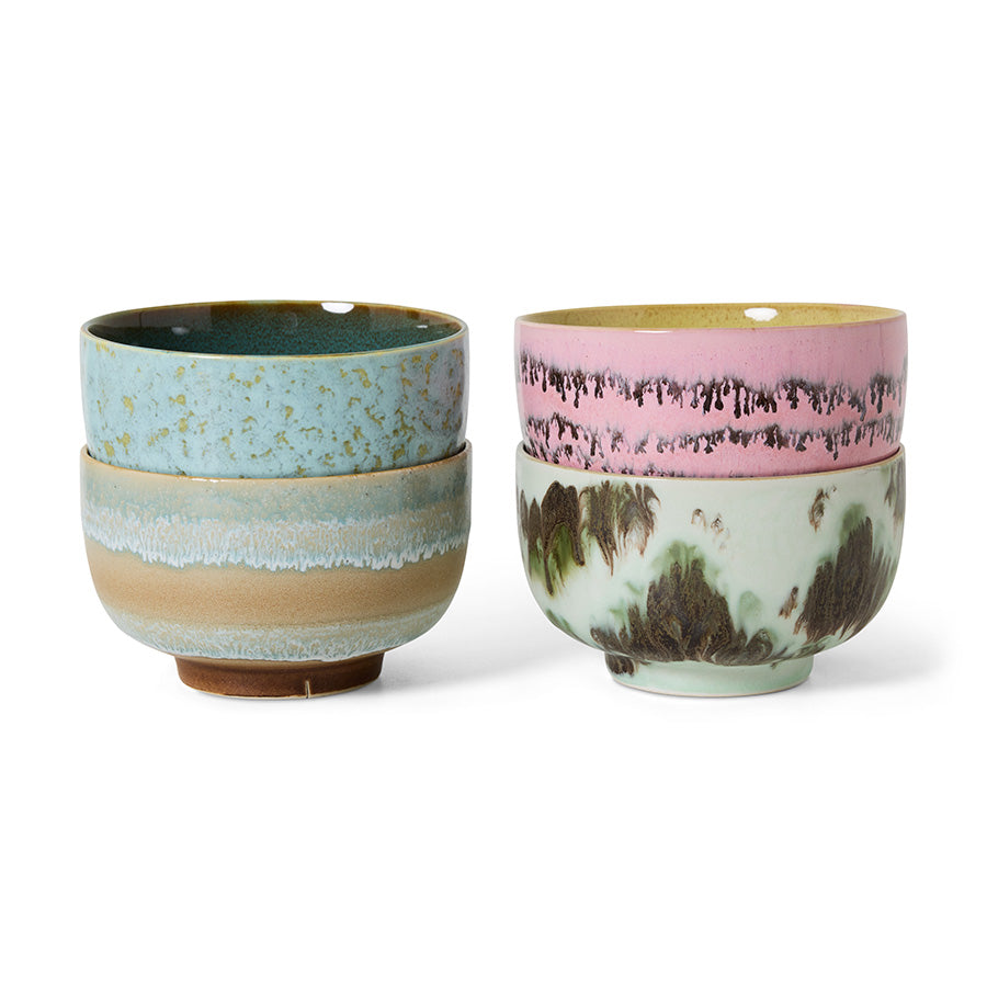 Two ceramic cups with multicolored glaze patterns on a white background