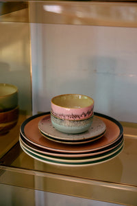Stack of ceramic bowls and plates on a reflective surface