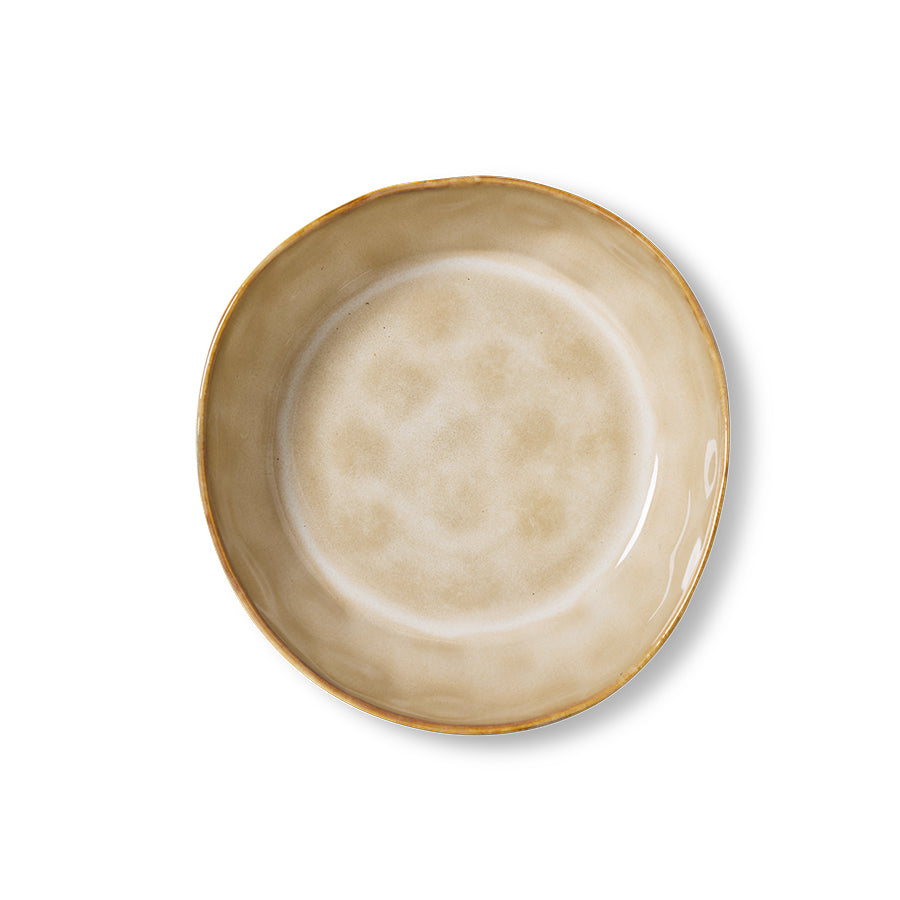 Beige ceramic bowl with gold rim on a white background