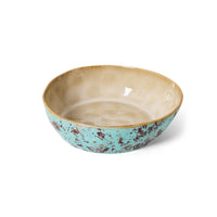Ceramic bowl with turquoise exterior and beige interior on a white background