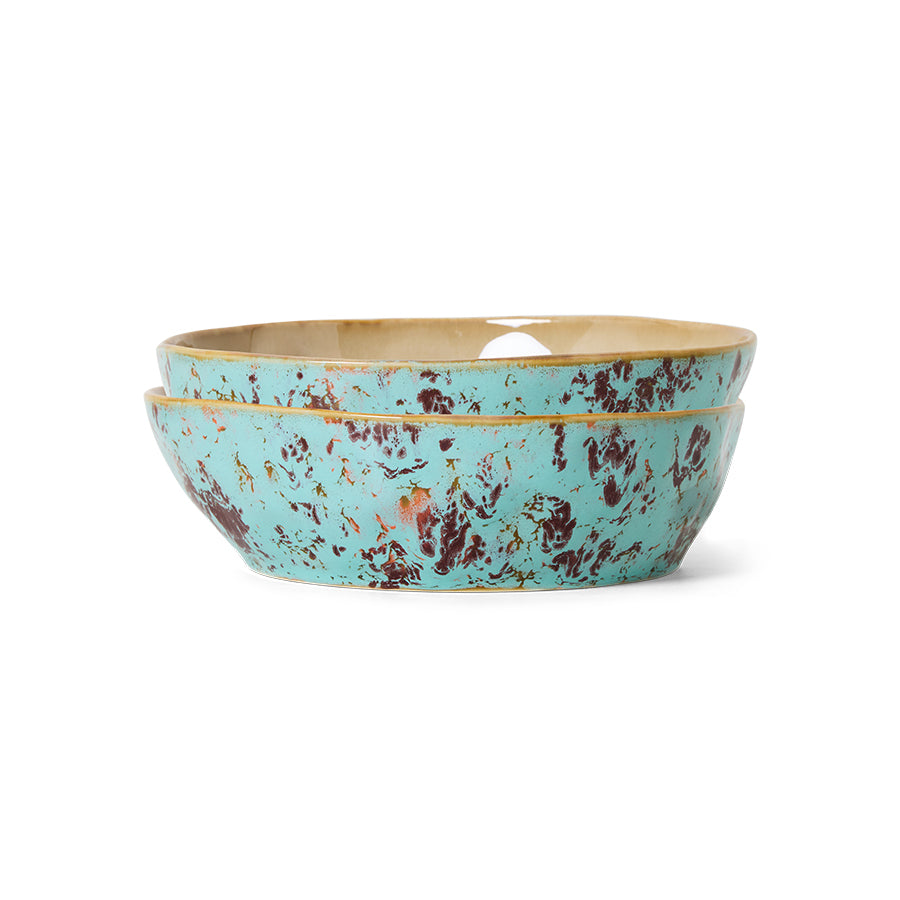 Turquoise ceramic bowl with gold rim on a white background