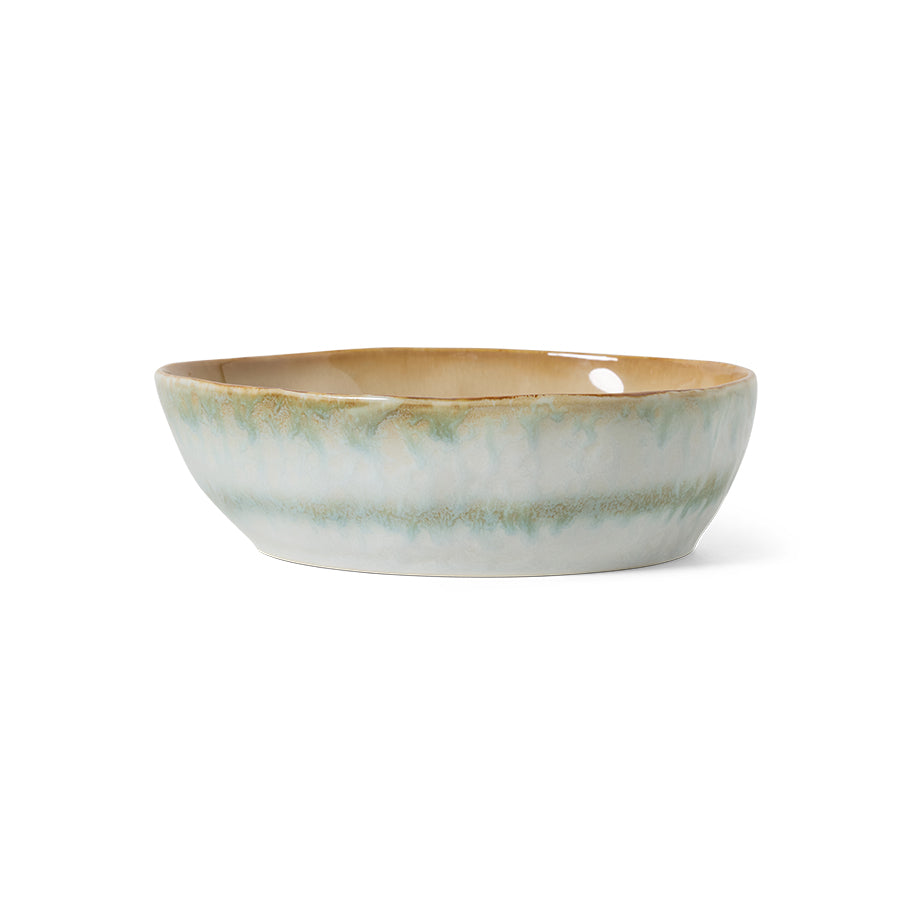 Ceramic bowl with a green and beige glaze on a white background