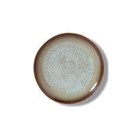 Ceramic plate with speckled design on a white background