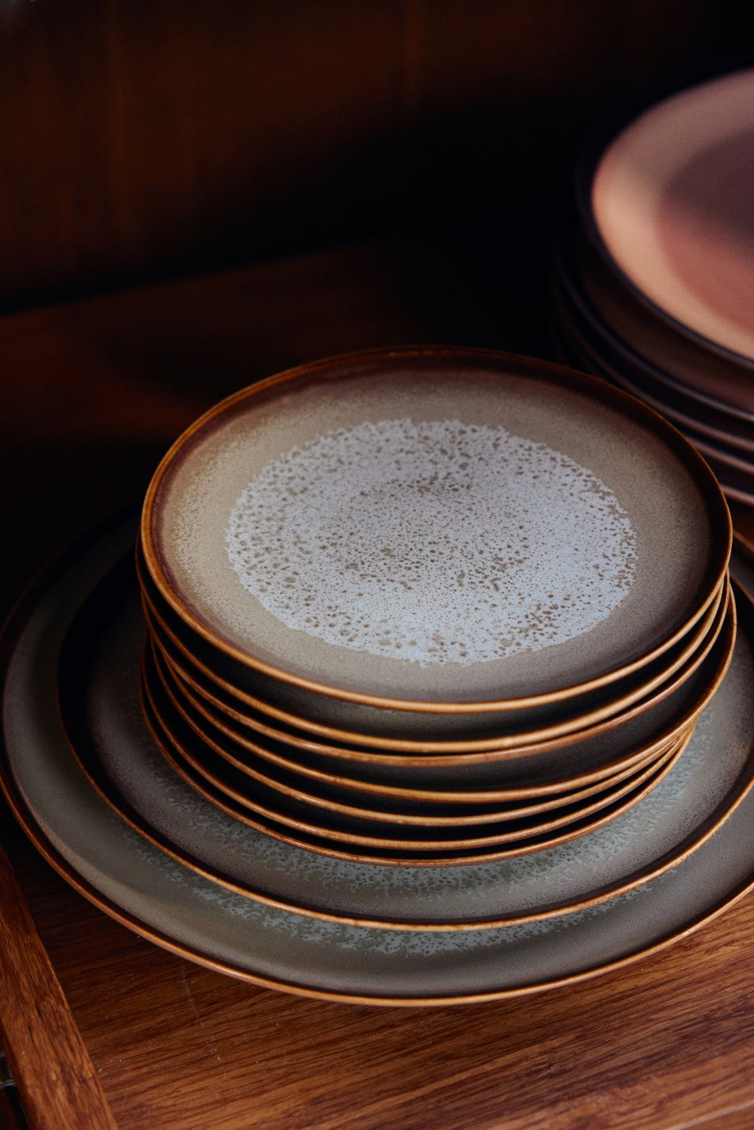Stack of ceramic plates with a textured surface on a wooden surface