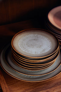 Stack of ceramic plates with a textured surface on a wooden surface