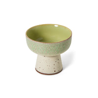 Ceramic bowl with green interior and beige exterior on a white background