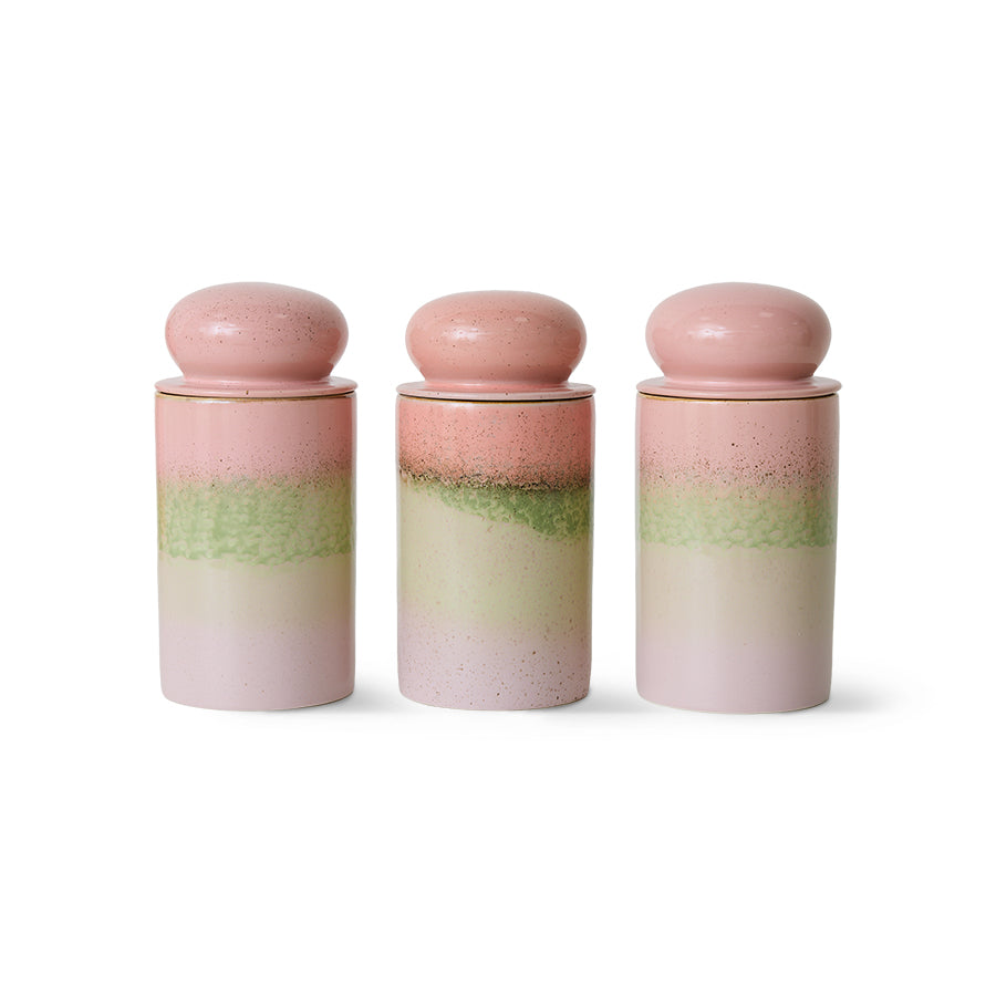 Three gradient ceramic jars with pink and green layers on a white background