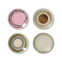 Four ceramic plates with different color patterns on a white background