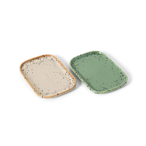 Two ceramic trays, one beige with speckles and one green, on a white background.