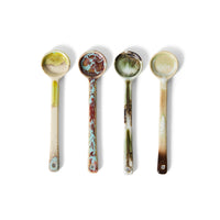 Four ceramic spoons with marbled patterns on a white background