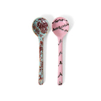 Two marbled patterned spoons on a white background