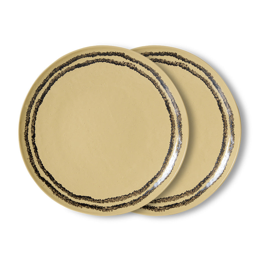 Two beige plates with black rim on a white background