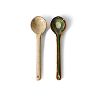Two ceramic spoons with speckled patterns on a white background