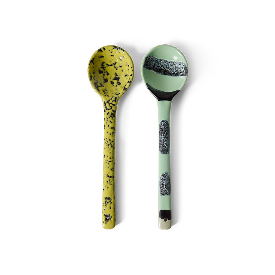 Two ceramic spoons with speckled patterns on a white background