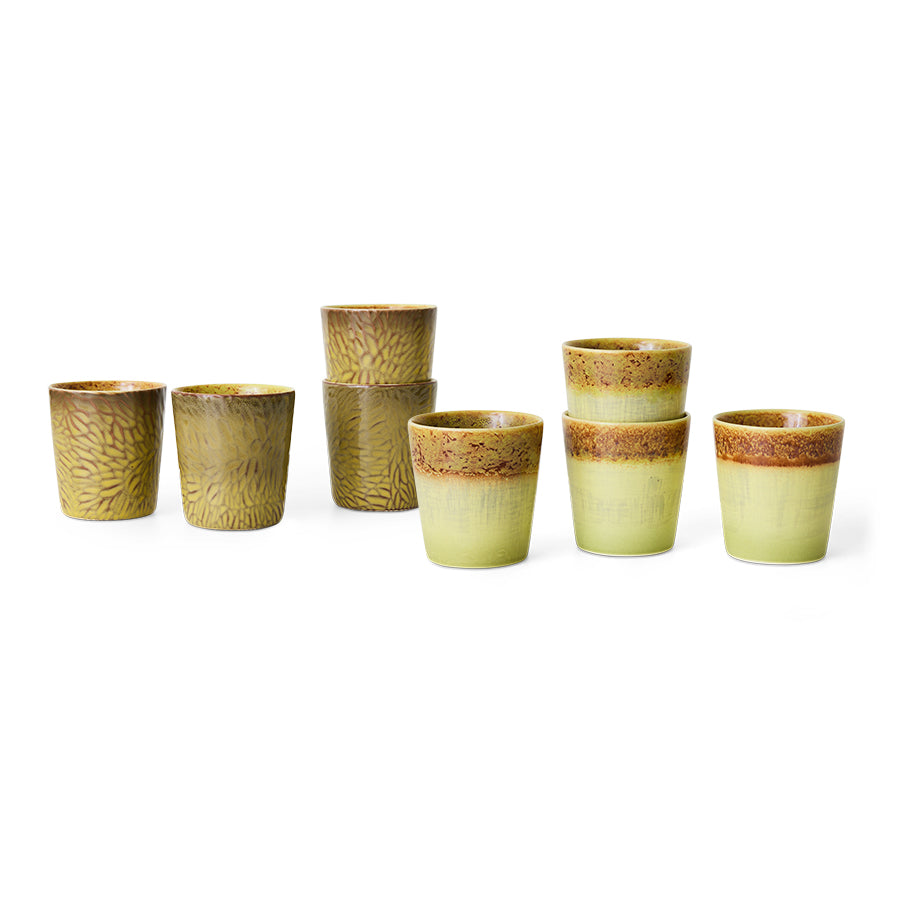 Set of ceramic cups with brown and green glaze on a white background