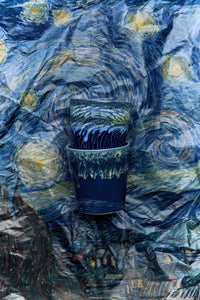 two cups  on a textured surface resembling 'Starry Night' by Van Gogh