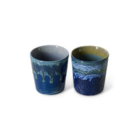 Two ceramic cups with blue and green abstract patterns on a white background