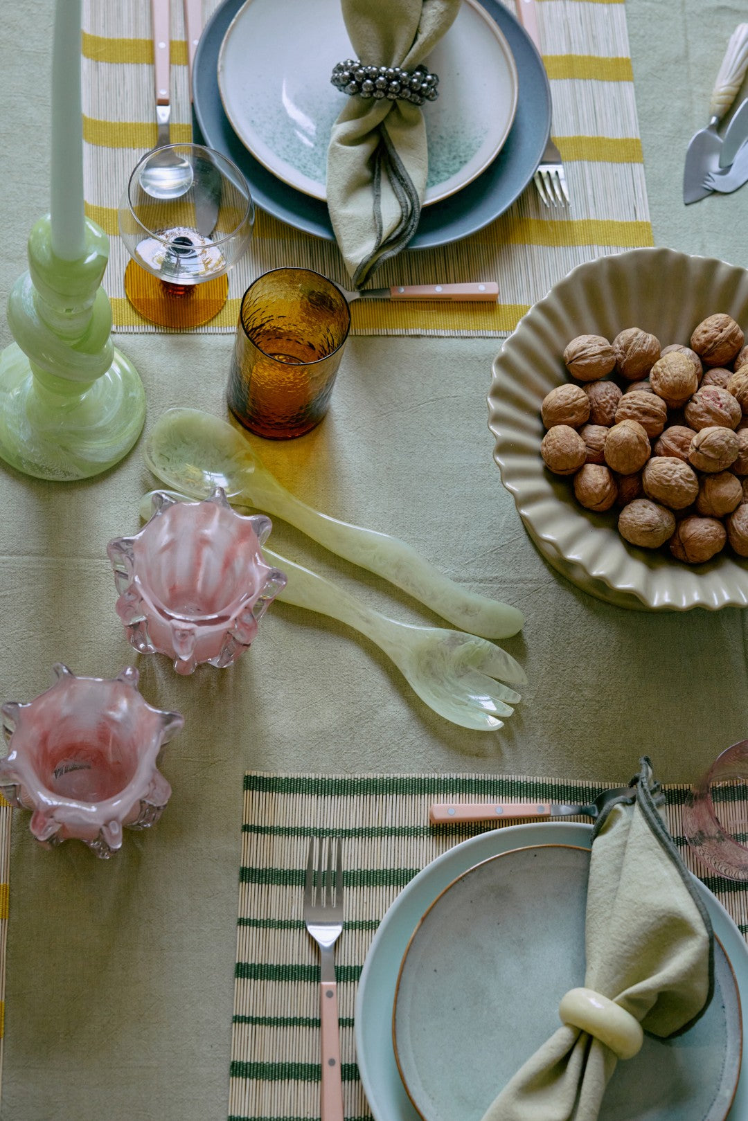 Dining table setting with plates, cutlery, and decorative items on a checkered tablecloth.