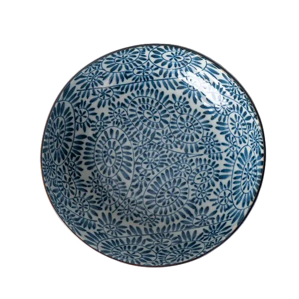 Decorative blue and white ceramic plate on a white surface