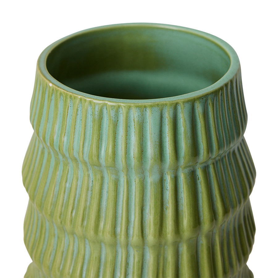 Green ceramic vase with textured surface on a white background
