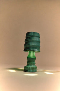 Green textured table lamp on a beige background