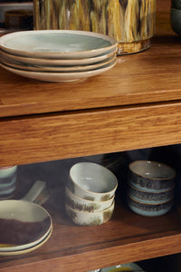 wooden cabinet with bowls and stack of light green side plates