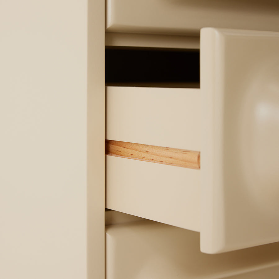 Beige drawer with wooden handle in a cabinet