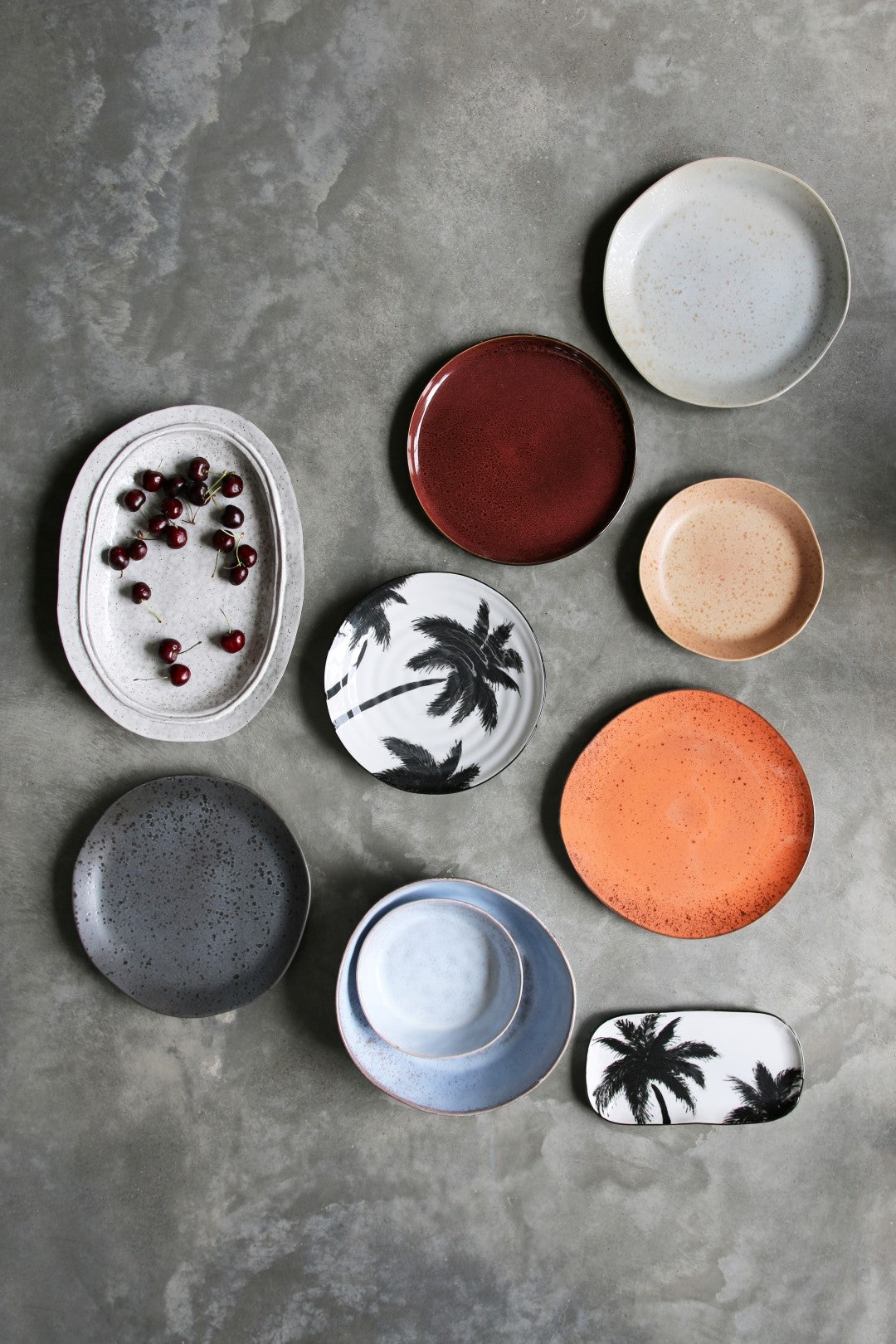 Collection of various ceramic plates on a gray surface