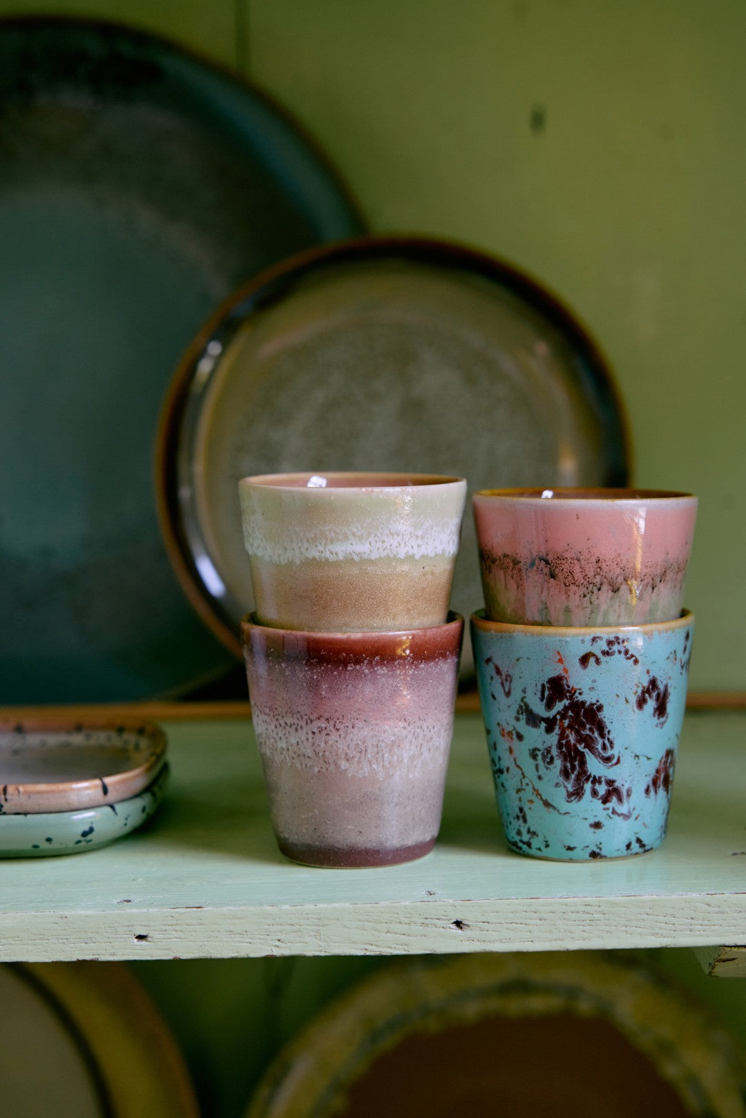 Stacked ceramic cups with rustic glaze on a wooden surface