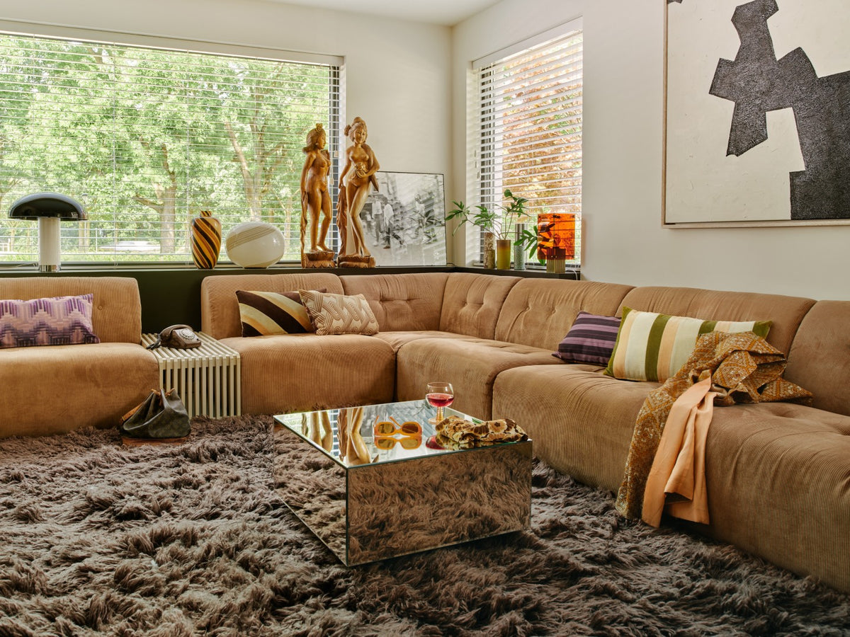 Living room with a brown sectional sofa, coffee table, and decorative items.