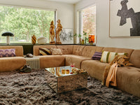 Living room with a brown sectional sofa, coffee table, and decorative items.