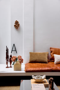 Modern living room with brown leather sofa, decorative pillows, and wall art.