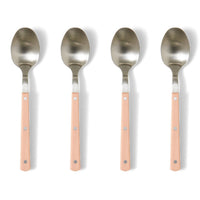 Four spoons with metallic heads and pink handles on a white background