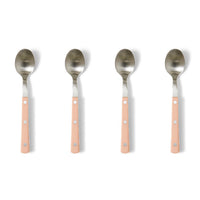 Four spoons with pink handles on a white background