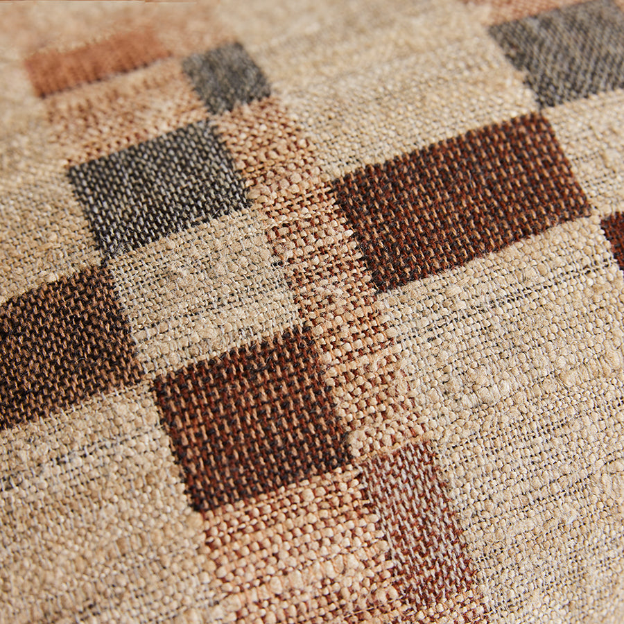 Close-up of a checkered patterned fabric with brown and beige squares.