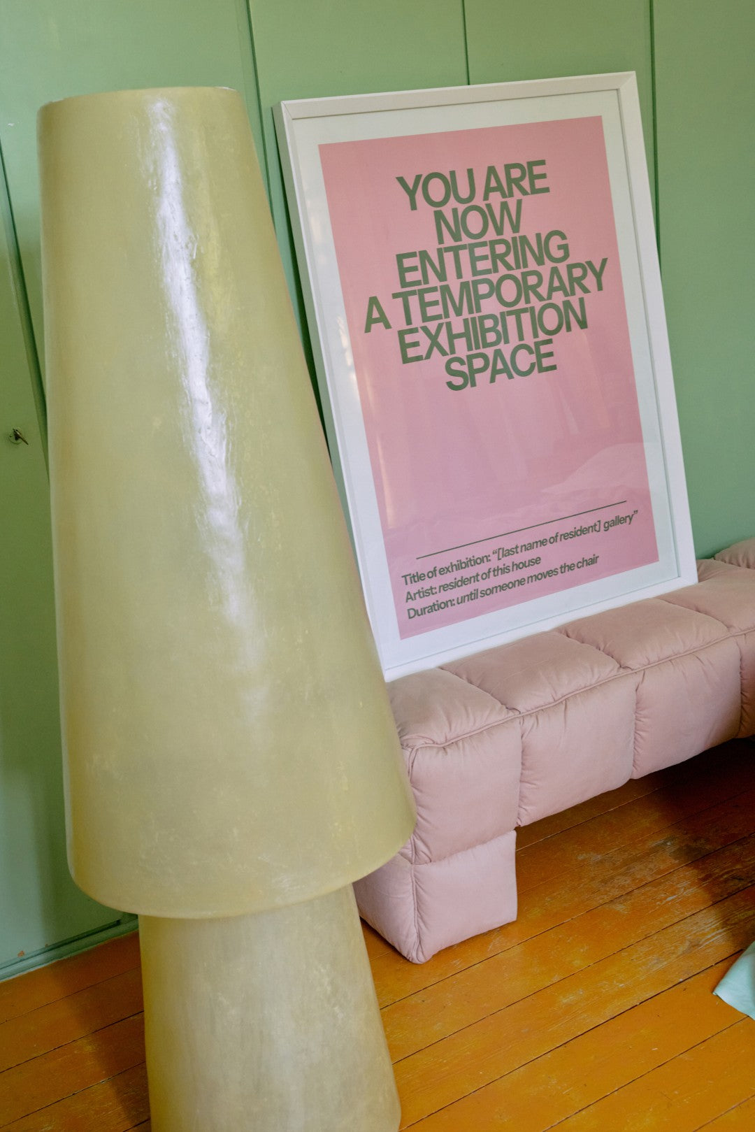 yellow lamp, pink bench and artwork in white wooden frame